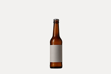 Image showing Empty golden colored beer bottle. Isolated on white studio background