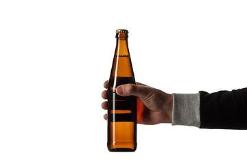 Image showing Empty golden colored beer bottle in male hand. Isolated on white studio background