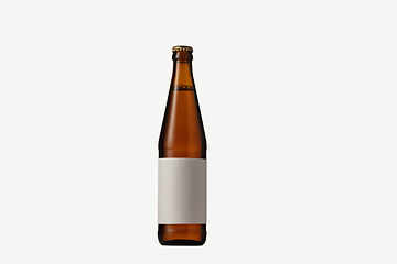 Image showing Empty golden colored beer bottle. Isolated on white studio background