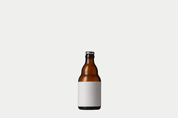 Image showing Empty golden colored beer bottle. Isolated on white studio background