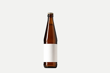 Image showing Empty golden colored beer bottle. Isolated on white studio background