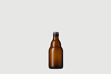 Image showing Empty golden colored beer bottle. Isolated on white studio background