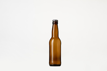 Image showing Empty golden colored beer bottle. Isolated on white studio background