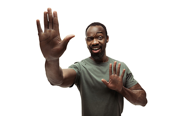 Image showing Young african-american man with funny, unusual popular emotions and gestures isolated on white studio background