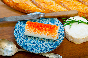 Image showing French cheese and fresh  baguette on a wood cutter