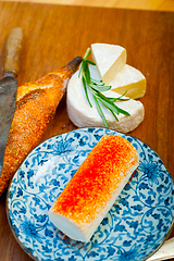 Image showing French cheese and fresh  baguette on a wood cutter