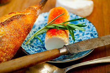 Image showing French cheese and fresh  baguette on a wood cutter