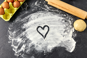 Image showing heart on flour, rolling pin, eggs and dough