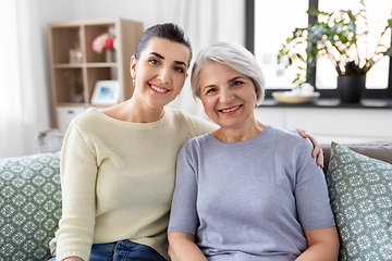 Image showing senior mother with adult daughter hugging at home