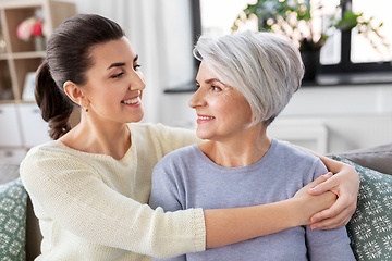 Image showing senior mother with adult daughter hugging at home