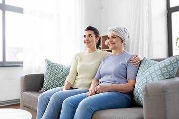 Image showing senior mother with adult daughter hugging at home