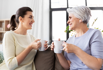 Image showing senior mother and adult daughter drinking coffee