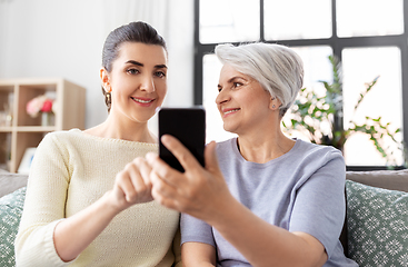 Image showing daughter and senior mother with smartphone at home