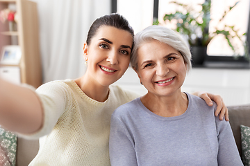 Image showing senior mother with daughter taking selfie at home