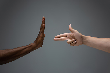 Image showing Racial tolerance. Respect social unity. African and caucasian hands gesturing isolated on gray studio background