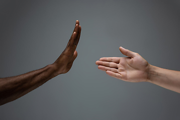 Image showing Racial tolerance. Respect social unity. African and caucasian hands gesturing isolated on gray studio background