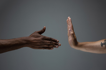 Image showing Racial tolerance. Respect social unity. African and caucasian hands gesturing isolated on gray studio background