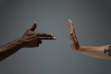 Image showing Racial tolerance. Respect social unity. African and caucasian hands gesturing isolated on gray studio background