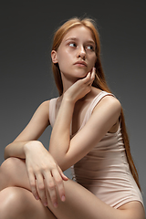 Image showing Portrait of beautiful redhead woman isolated on grey studio background. Concept of beauty, skin care, fashion and style