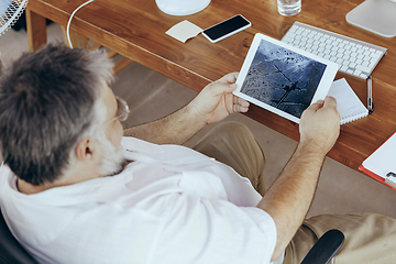 Image showing Businessman, manager in office with computer and fan cooling off, feeling hot, flushed