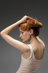 Image showing Portrait of beautiful redhead woman isolated on grey studio background. Concept of beauty, skin care, fashion and style