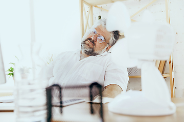 Image showing Businessman, manager in office with computer and fan cooling off, feeling hot, flushed