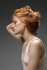 Image showing Portrait of beautiful redhead woman isolated on grey studio background. Concept of beauty, skin care, fashion and style