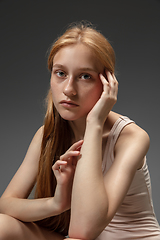 Image showing Portrait of beautiful redhead woman isolated on grey studio background. Concept of beauty, skin care, fashion and style