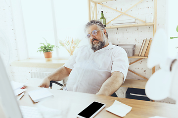 Image showing Businessman, manager in office with computer and fan cooling off, feeling hot, flushed