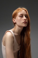 Image showing Portrait of beautiful redhead woman isolated on grey studio background. Concept of beauty, skin care, fashion and style