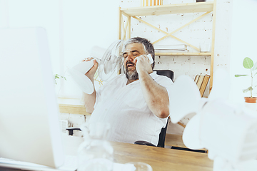 Image showing Businessman, manager in office with computer and fan cooling off, feeling hot, flushed