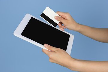 Image showing Female hands with debit, credit card and tablet with copyspace on blank screen