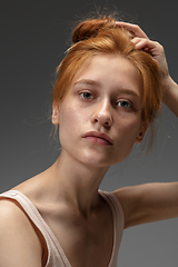 Image showing Portrait of beautiful redhead woman isolated on grey studio background. Concept of beauty, skin care, fashion and style