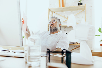 Image showing Businessman, manager in office with computer and fan cooling off, feeling hot, flushed