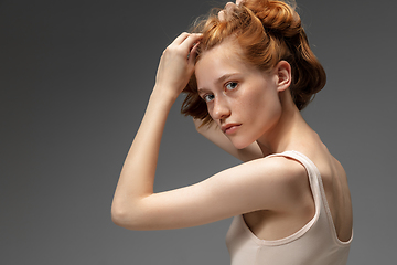 Image showing Portrait of beautiful redhead woman isolated on grey studio background. Concept of beauty, skin care, fashion and style