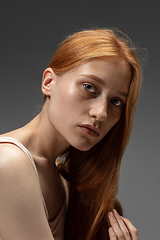 Image showing Portrait of beautiful redhead woman isolated on grey studio background. Concept of beauty, skin care, fashion and style