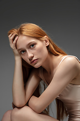 Image showing Portrait of beautiful redhead woman isolated on grey studio background. Concept of beauty, skin care, fashion and style