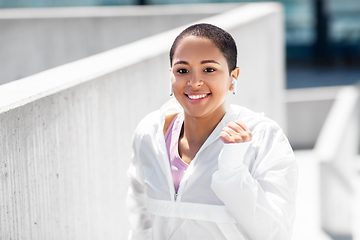 Image showing african american woman running upstairs outdoors