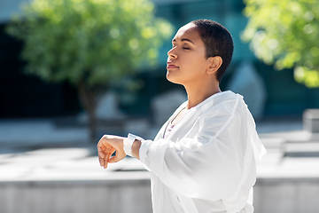 Image showing young woman with smart watch breathing outdoors