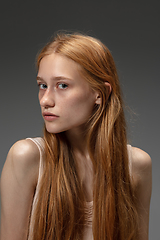 Image showing Portrait of beautiful redhead woman isolated on grey studio background. Concept of beauty, skin care, fashion and style
