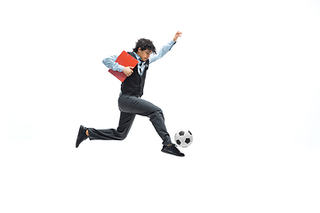 Image showing Man in office clothes playing football or soccer with ball on white background. Unusual look for businessman in motion, action. Sport, healthy lifestyle.