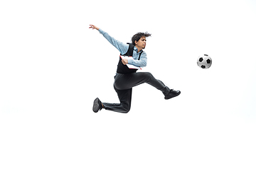 Image showing Man in office clothes playing football or soccer with ball on white background. Unusual look for businessman in motion, action. Sport, healthy lifestyle.