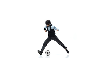 Image showing Man in office clothes playing football or soccer with ball on white background. Unusual look for businessman in motion, action. Sport, healthy lifestyle.