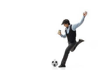 Image showing Man in office clothes playing football or soccer with ball on white background. Unusual look for businessman in motion, action. Sport, healthy lifestyle.