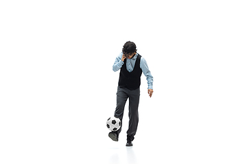 Image showing Man in office clothes playing football or soccer with ball on white background. Unusual look for businessman in motion, action. Sport, healthy lifestyle.