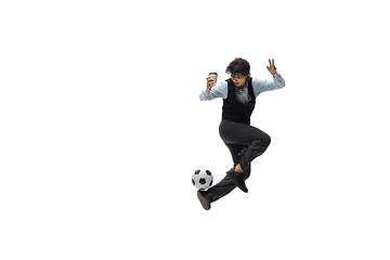 Image showing Man in office clothes playing football or soccer with ball on white background. Unusual look for businessman in motion, action. Sport, healthy lifestyle.