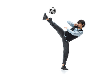 Image showing Man in office clothes playing football or soccer with ball on white background. Unusual look for businessman in motion, action. Sport, healthy lifestyle.