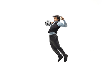 Image showing Man in office clothes playing football or soccer with ball on white background. Unusual look for businessman in motion, action. Sport, healthy lifestyle.