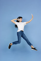 Image showing Portrait of young asian woman isolated on blue studio background