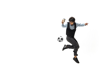 Image showing Man in office clothes playing football or soccer with ball on white background. Unusual look for businessman in motion, action. Sport, healthy lifestyle.